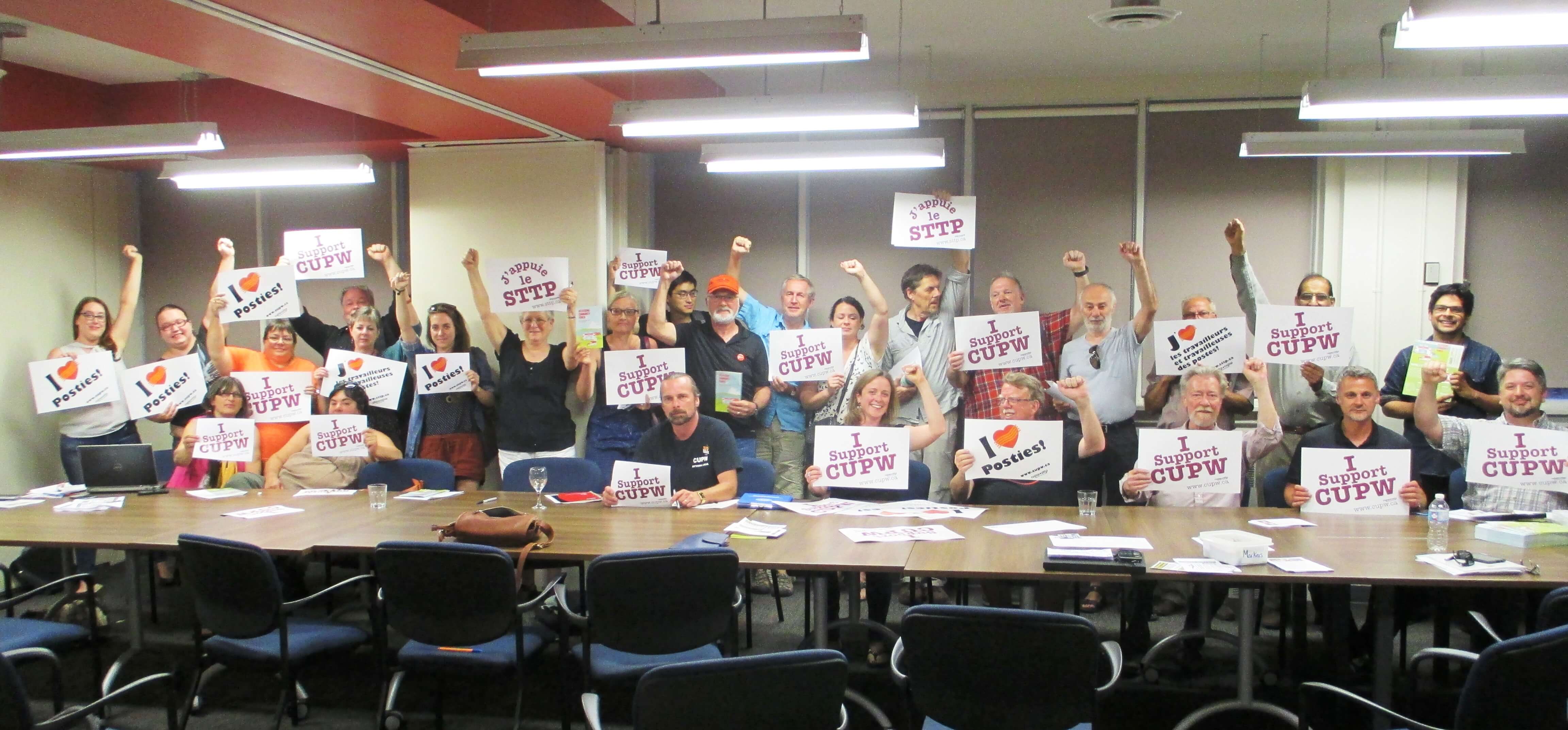 Photo of Solidarity Against Austerity group holding placards of support for postal workers